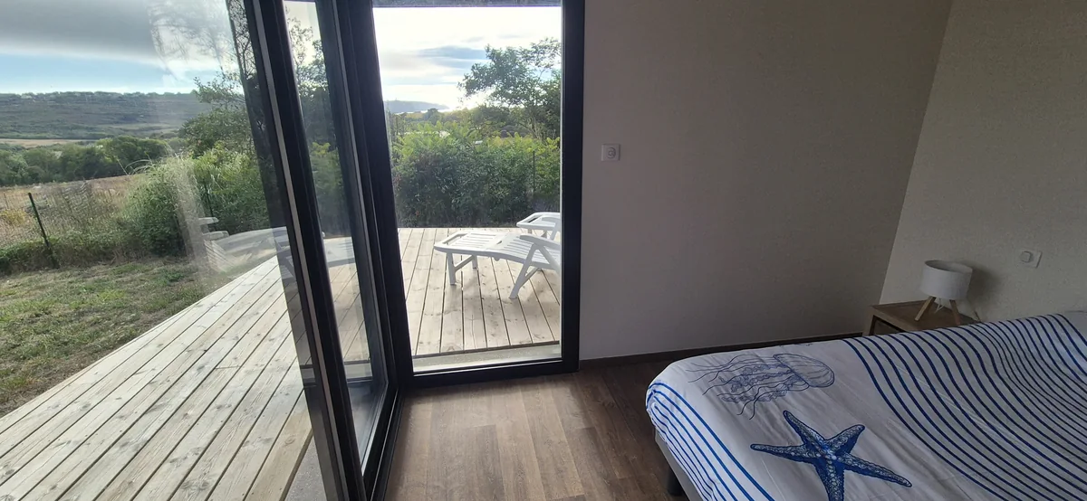 Maison 1 · Vue mer et grande terrasse — Chambre ouverte sur la terrasse